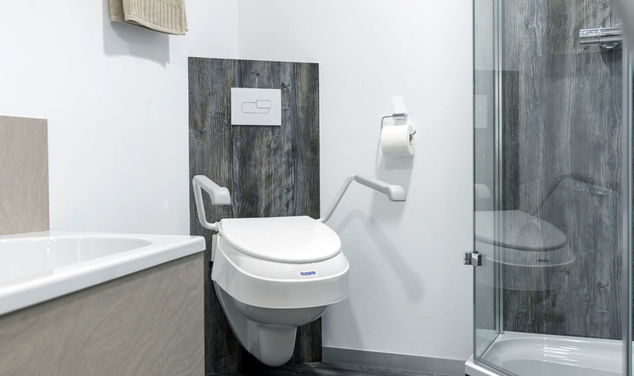 Toilet med toiletforhøjer og armlæn fra Invacare Aquatec
