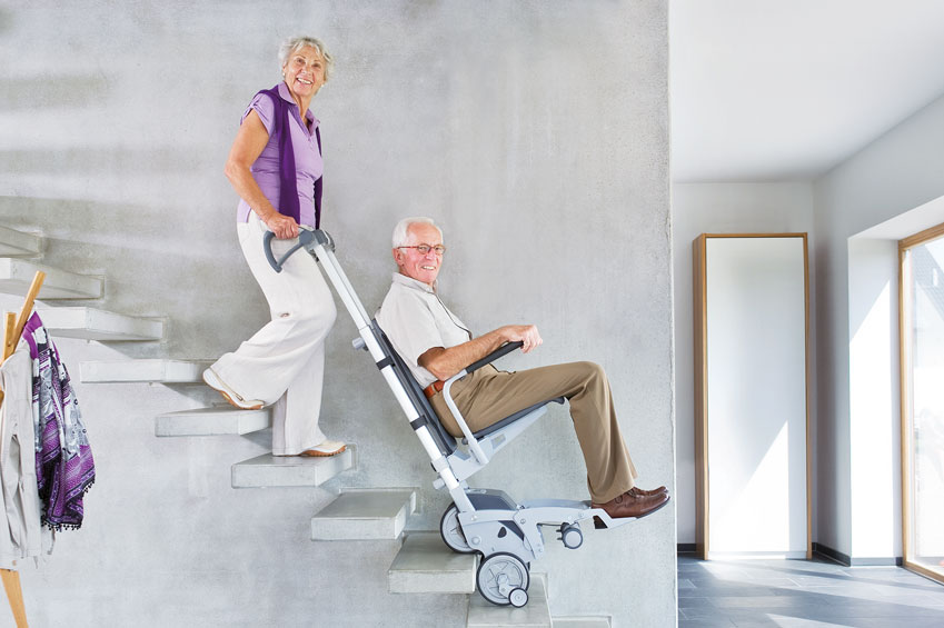 Ældre kvinder lifter and ved ad trappe ved hjælpe af trappelift
